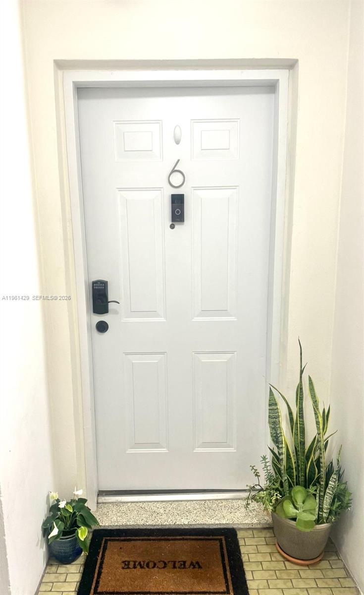 A white front door with a digital lock and a number six sits above a welcome mat — 755 SW 6th St # 6, Miami FL 33130, MIAMI, FL
