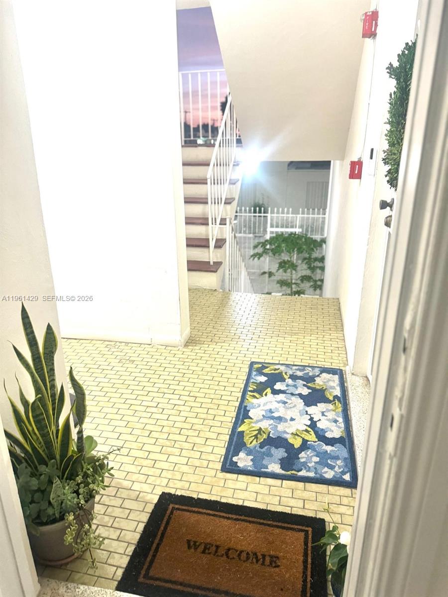 An outdoor entryway features a tiled floor, a welcome mat, a floral rug, and stairs — 755 SW 6th St # 6, Miami FL 33130, MIAMI, FL