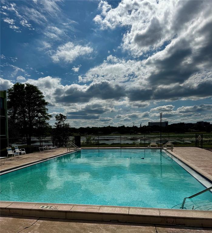 An outdoor swimming pool with a shallow end and a view of a lake — 1130 N LAKE PARKER AVENUE UNIT E332, LAKELAND, FL