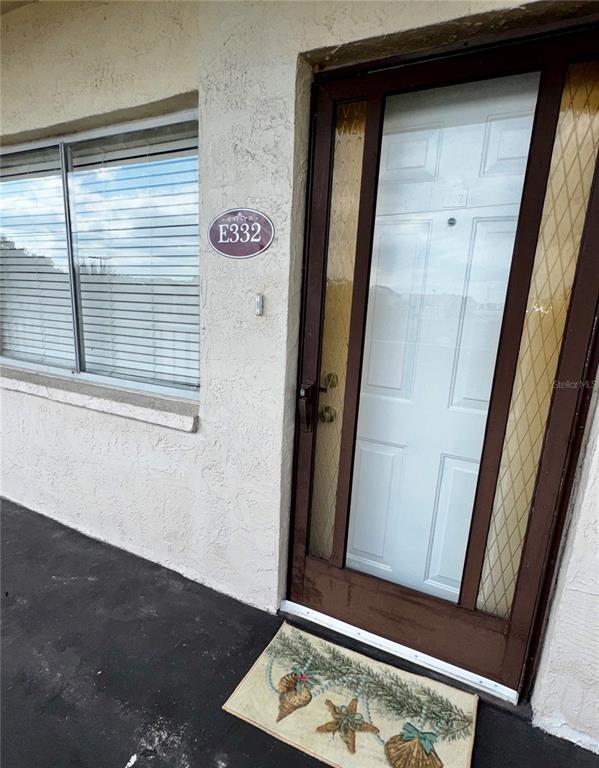 A white door with a glass storm door and a window with blinds — 1130 N LAKE PARKER AVENUE UNIT E332, LAKELAND, FL