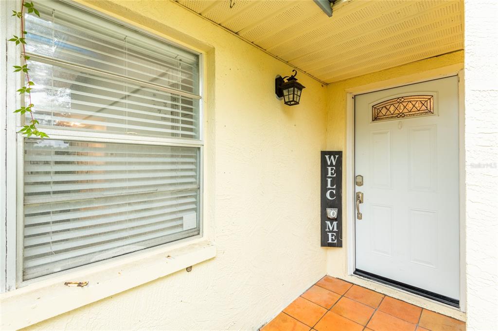 A front porch features a white door, a window with blinds, and a welcome sign — 1944 ELAINE DRIVE UNIT 1944, CLEARWATER, FL