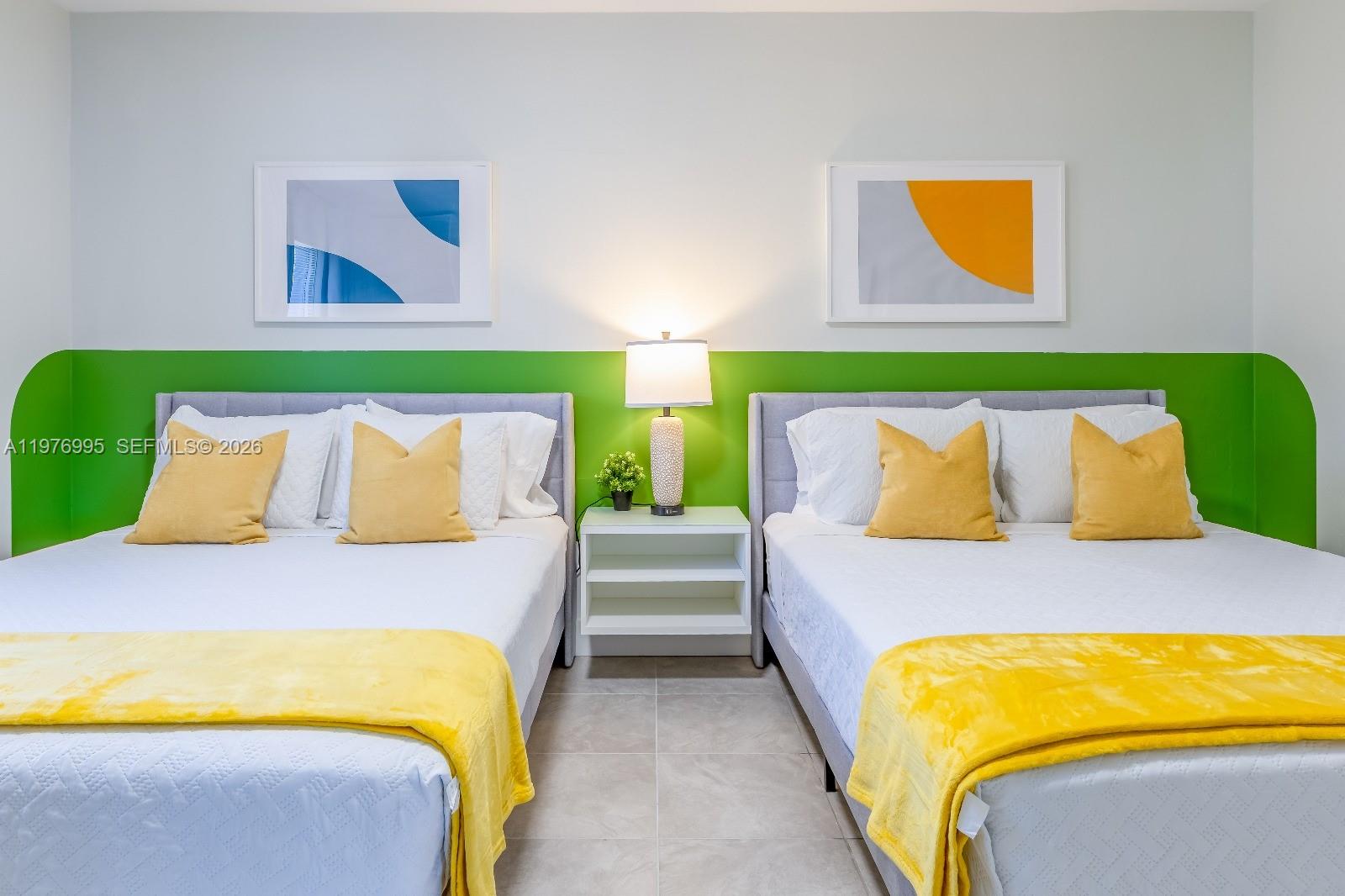 A bedroom features two beds with yellow accents and a green wall accent — 1836 NW 16th Ter, Miami FL 33125, MIAMI, FL