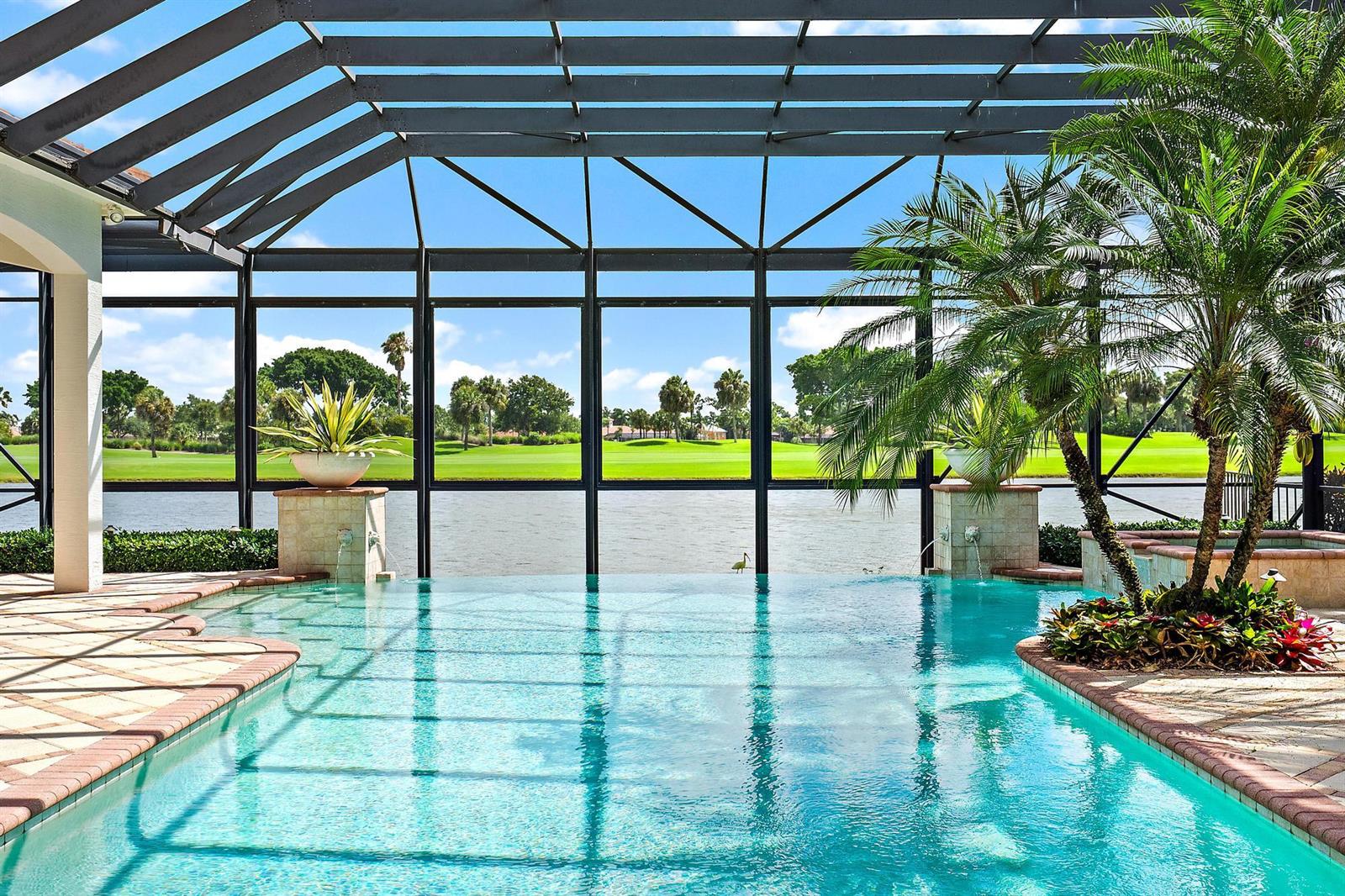A screened-in swimming pool overlooks a lake and a golf course on a sunny day — 7170 Winding Bay Lane, West Palm Beach FL 33412, WEST PALM BEACH, FL