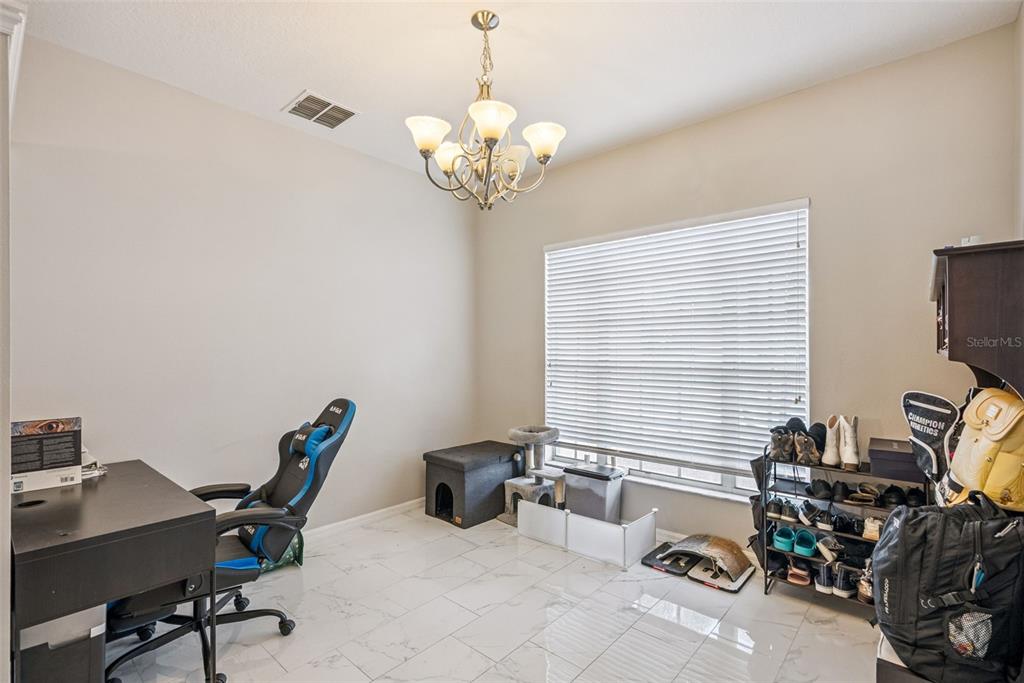 A home office features tile flooring, a chandelier, a desk, and a shoe rack — 13805 EAGLES GLEN COURT, ORLANDO, FL