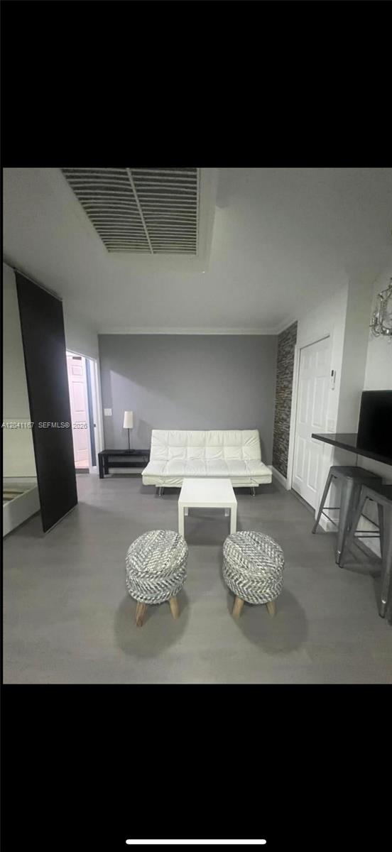 A living room features a white sofa, a coffee table, and two textured round stools — 4731 fillmore # 1, Hollywood FL 33021, HOLLYWOOD, FL
