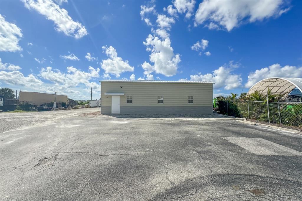 A single-story metal building with a white door and three windows sits on asphalt — 2820 AVENUE OF THE AMERICAS, ENGLEWOOD, FL