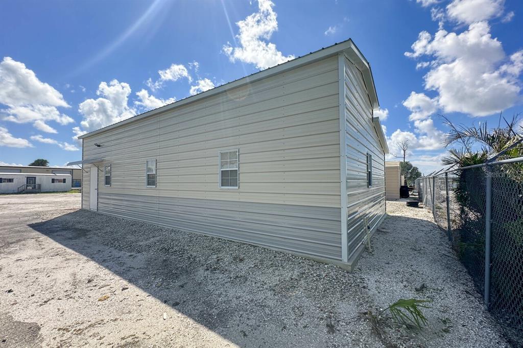 The exterior of a metal-sided building features a two-tone beige and gray finish — 2820 AVENUE OF THE AMERICAS, ENGLEWOOD, FL