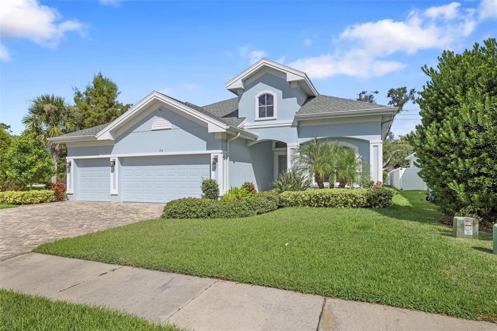 A light blue single-story house with a two-car garage and a paved driveway — 26 CONCORD DRIVE, DUNEDIN, FL