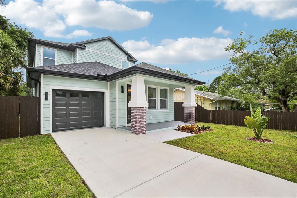 A two-story house with light green siding, a dark roof, and a front porch with columns — 3612 E CLIFTON STREET, TAMPA, FL