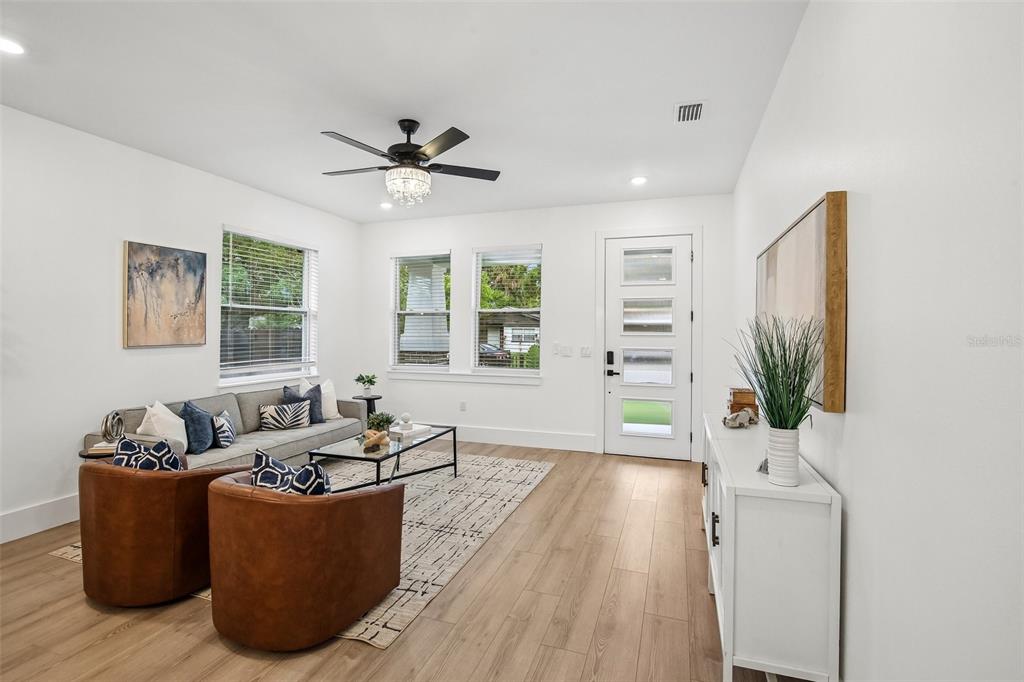 A living room features light wood floors, a ceiling fan, and a white front door — 3612 E CLIFTON STREET, TAMPA, FL