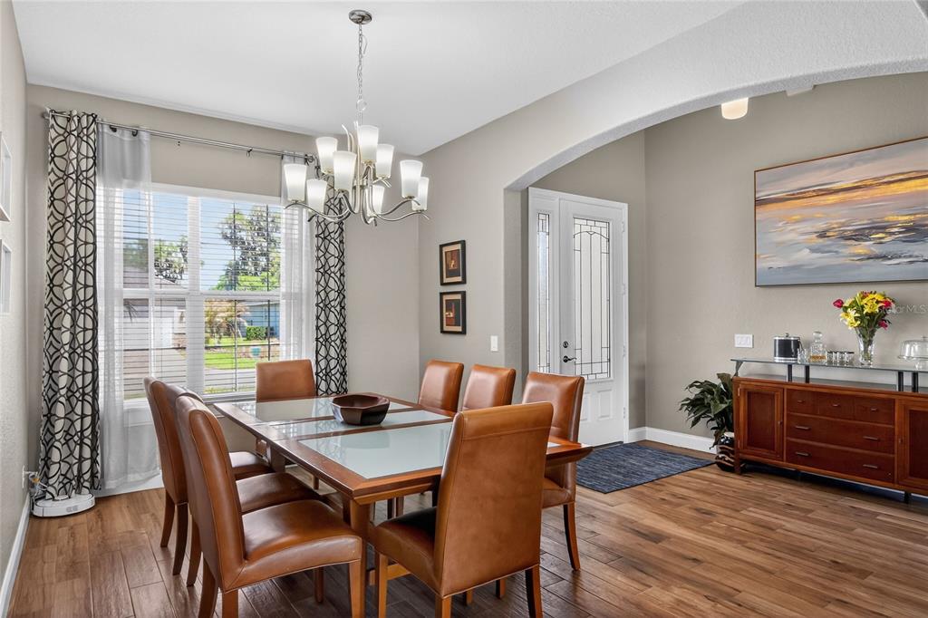 A dining room with a wooden table, leather chairs, a chandelier, and a wood sideboard — 3171 PEARLY DRIVE, LAKELAND, FL