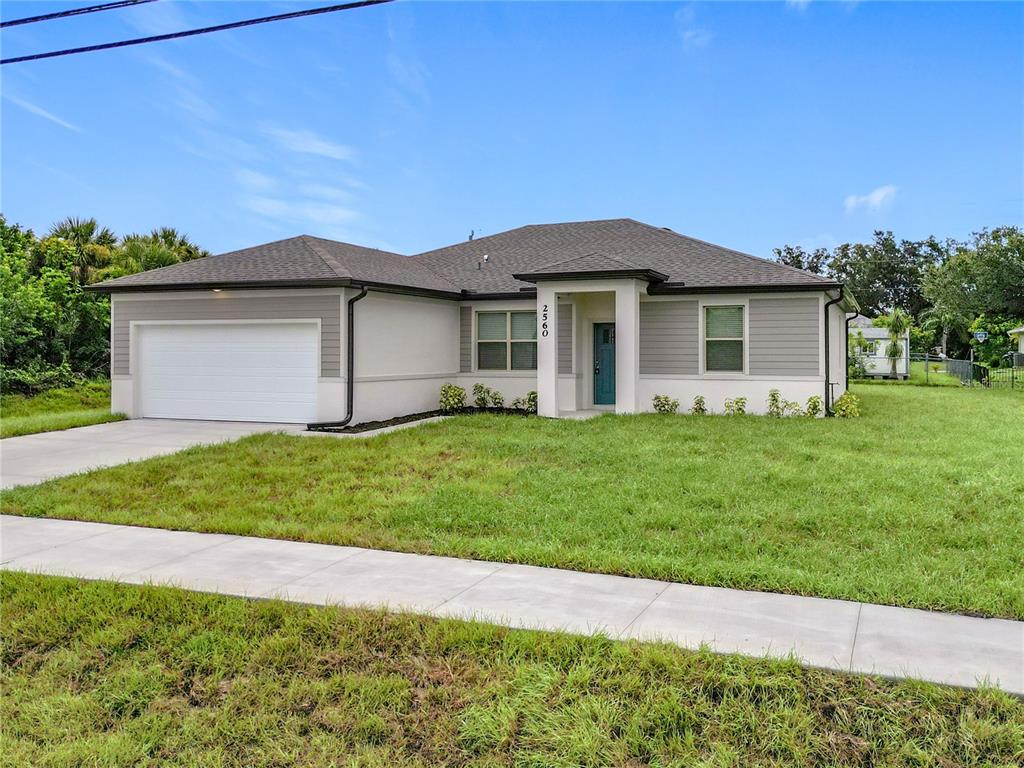 A single-story house with a white garage, gray siding, and a front entrance walkway — 2560 S BISCAYNE DRIVE, NORTH PORT, FL