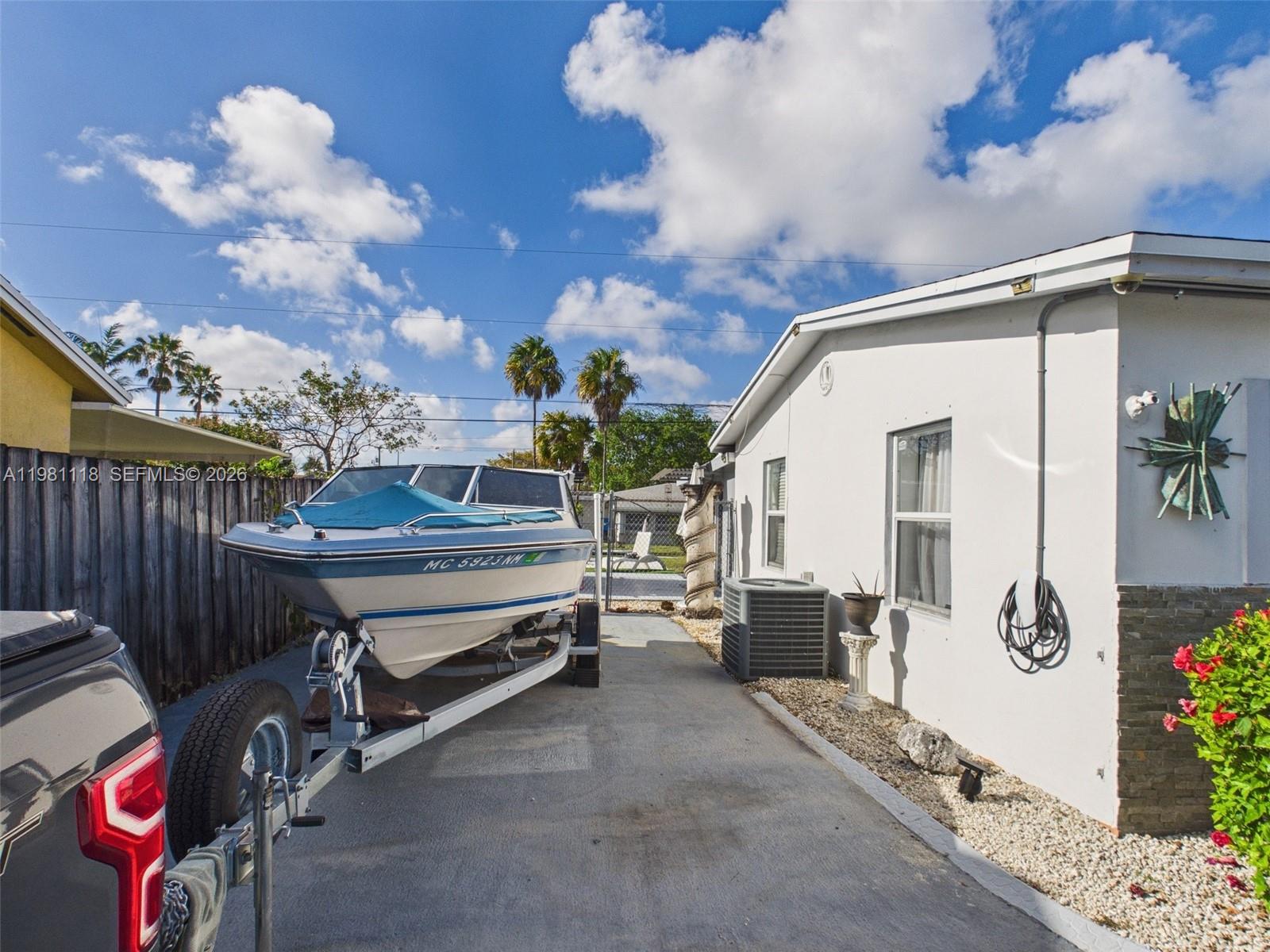 A boat on a trailer is parked in the side driveway of a white house — 9911 Haitian Dr, Cutler Bay FL 33189, CUTLER BAY, FL