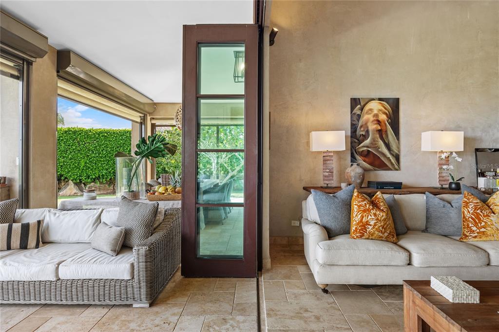 A living room with a wicker sofa and a beige sofa separated by a glass door — 2 OCEAN GOLF VILLA ROYAL ISABELA, ISABELA, PR