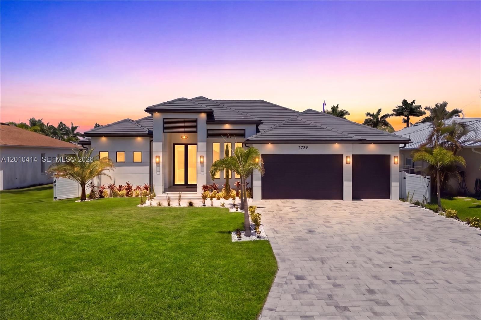 A modern single-story house with a paved driveway, dark garage doors, and a tiled roof — OTHER CITY - IN THE STATE OF FLORIDA, FL