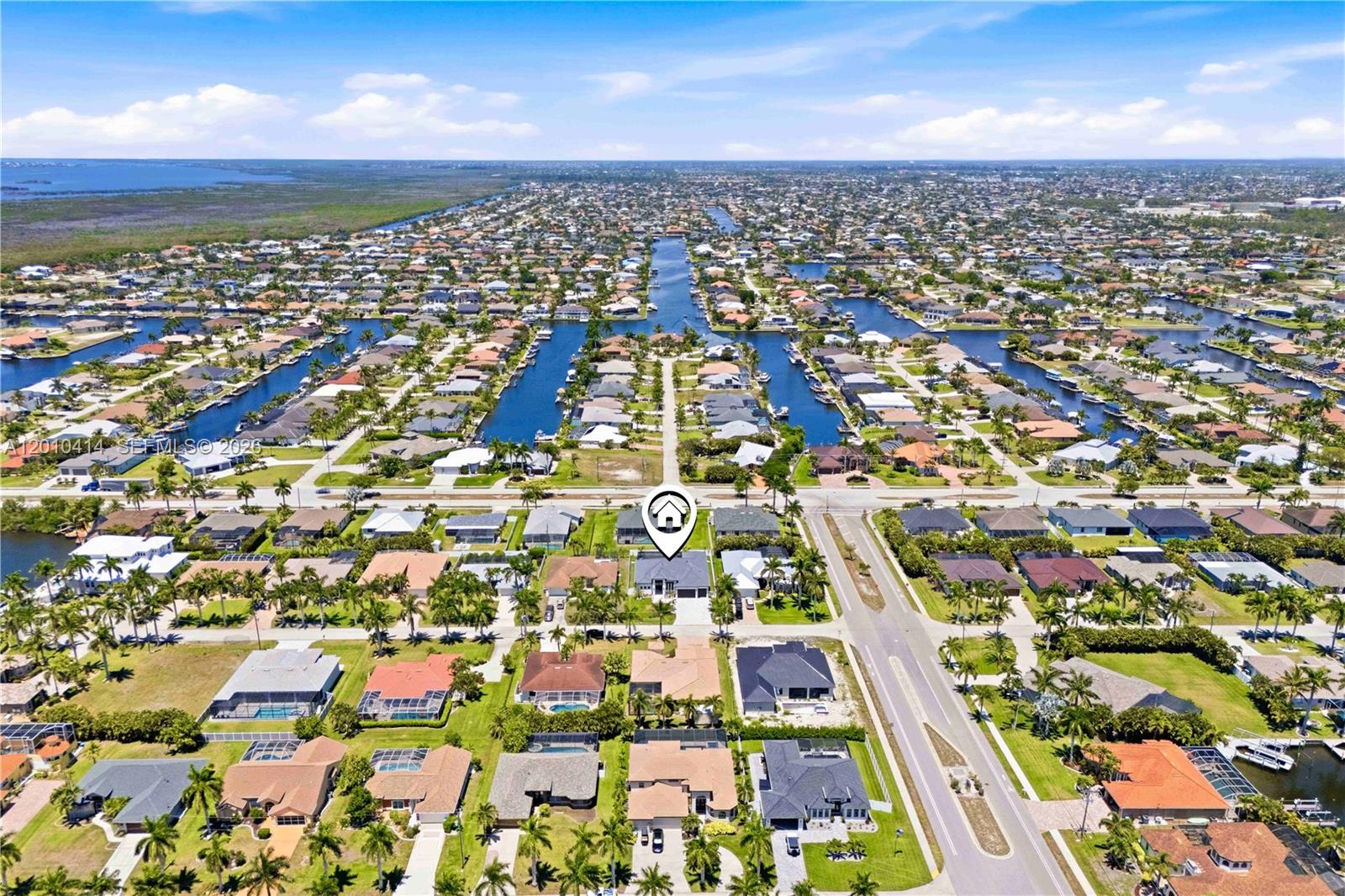 An aerial view shows a residential neighborhood with houses, canals, and a marked property — OTHER CITY - IN THE STATE OF FLORIDA, FL