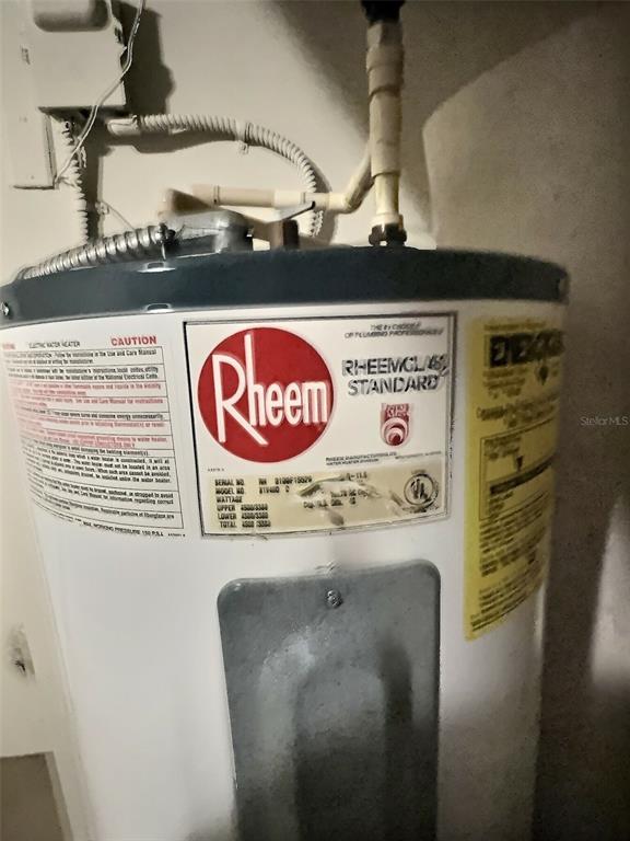 A Rheem electric water heater is installed in a utility area — 4751 TRAVINI CIRCLE UNIT 4-105, SARASOTA, FL