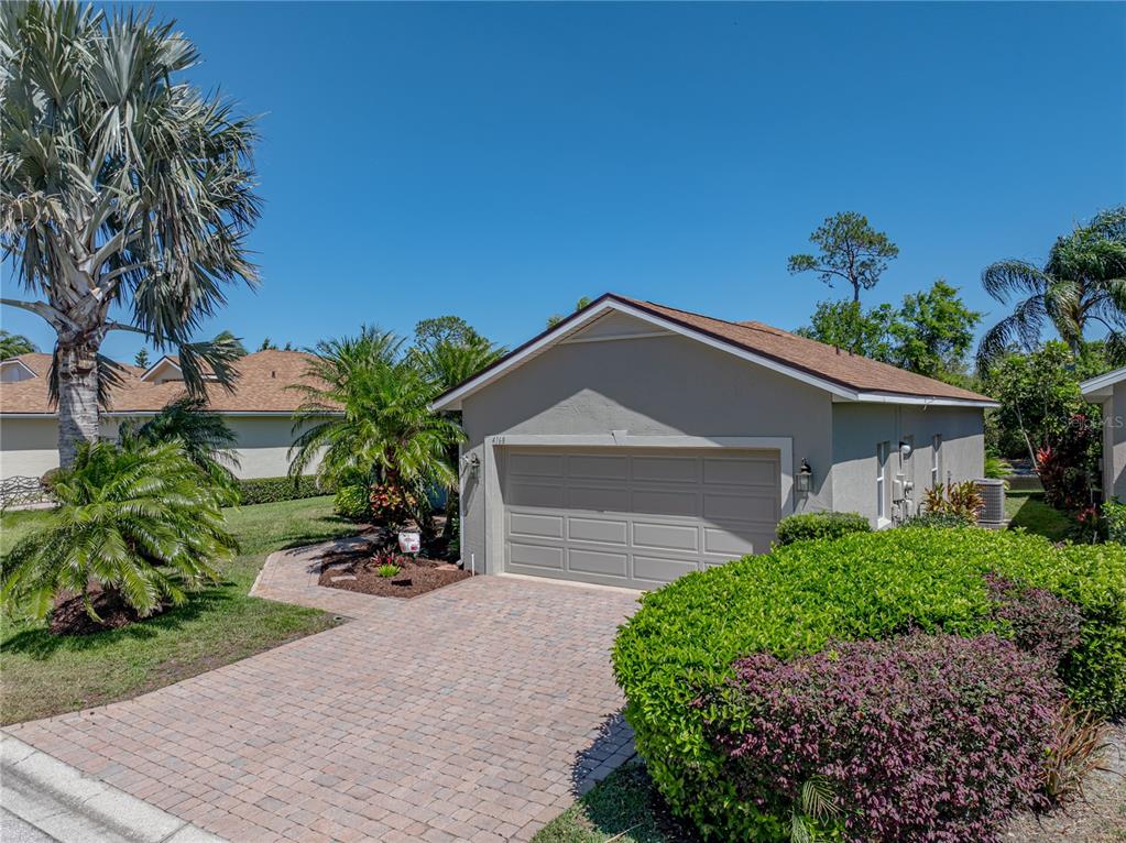 A single-story house with a beige exterior, a two-car garage, and a paved driveway — 4168 ABERDEEN LANE, LAKE WALES, FL