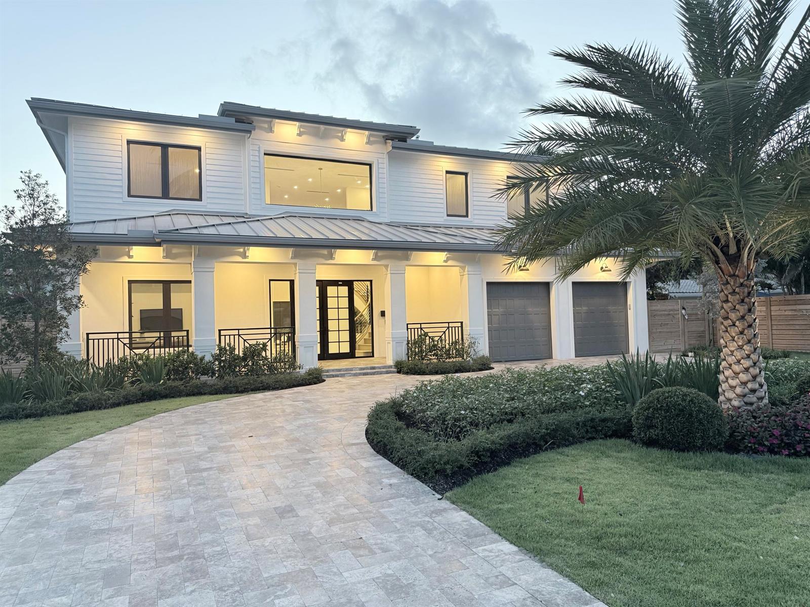 A modern dining room features a crystal chandelier, a wooden table, and floor-to-ceiling windows — 451 NW 7th Avenue, Boca Raton FL 33486, BOCA RATON, FL