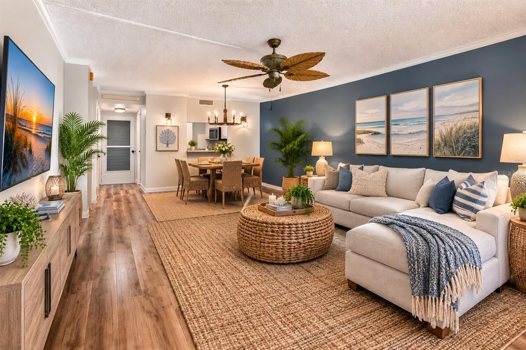 A living and dining area with wood floors, a blue accent wall, and coastal decor — 2621 COVE CAY DRIVE UNIT 802, CLEARWATER, FL