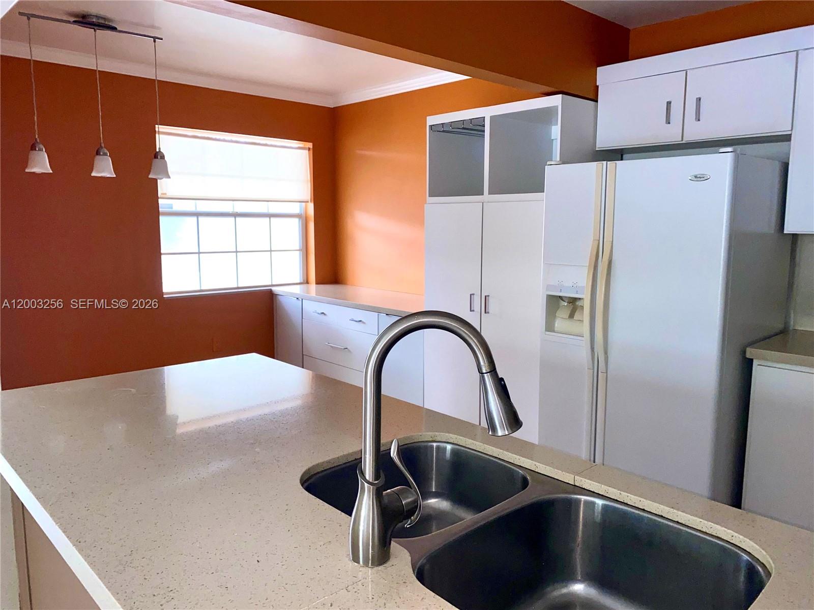 A kitchen features orange walls, white cabinetry, a double-basin sink, and a quartz countertop — 464 NE 210th Cir Ter # 10A, Miami FL 33179, MIAMI, FL