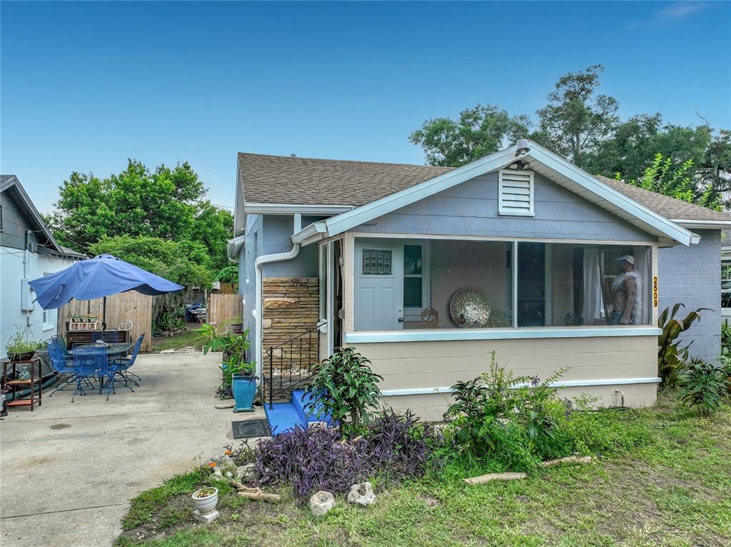 A light blue house with a screened-in front porch and a concrete driveway — 2509 SHANNON ROAD, ORLANDO, FL