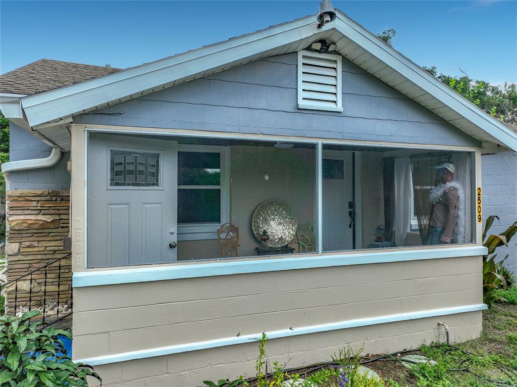 A screened-in front porch with a concrete block base and a white entry door — 2509 SHANNON ROAD, ORLANDO, FL