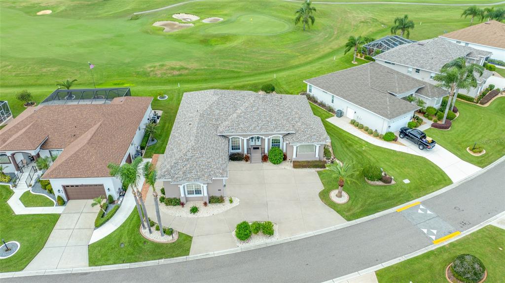 An aerial view shows a suburban house with a concrete driveway and a golf course — 6750 HUNTINGTON HILLS BOULEVARD, LAKELAND, FL