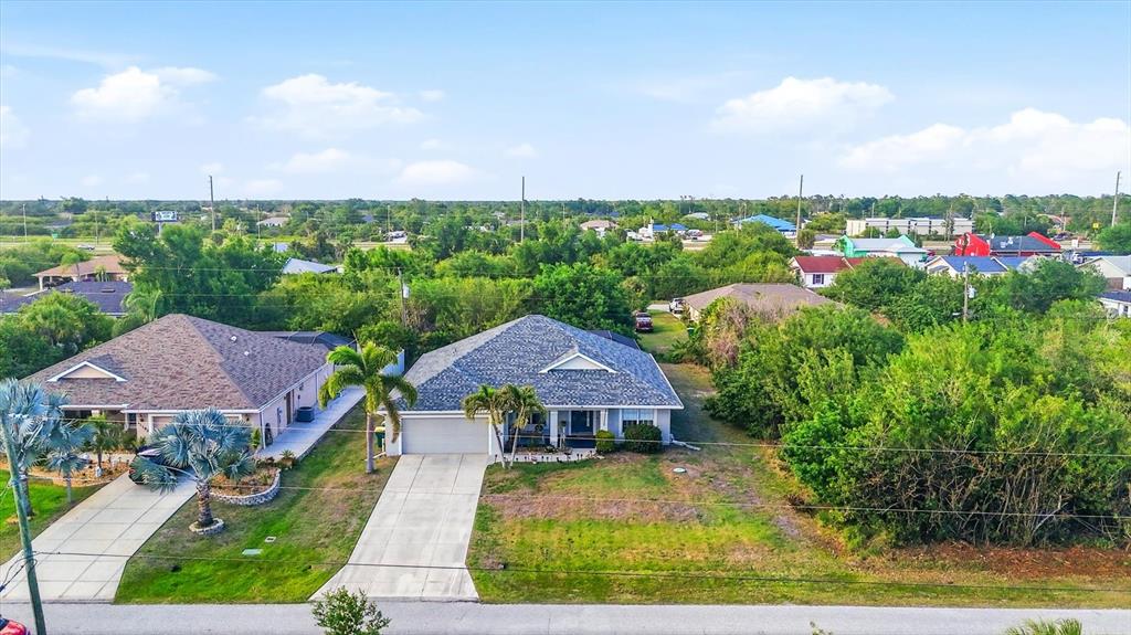 An aerial view shows two single-story residential houses with driveways and surrounding trees — 11200 CARNEGIE AVENUE, ENGLEWOOD, FL