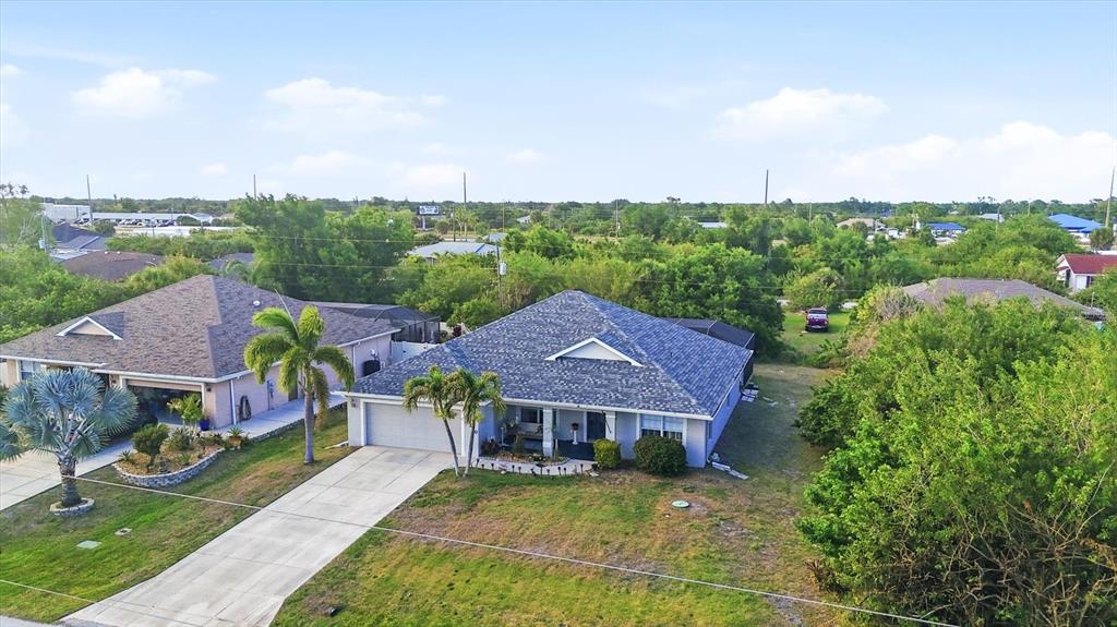 An aerial view shows two suburban houses with shingled roofs, driveways, and surrounding trees — 11200 CARNEGIE AVENUE, ENGLEWOOD, FL