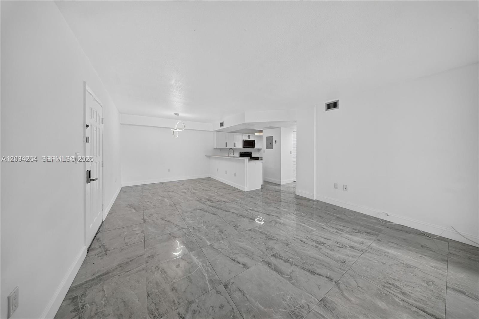 An open-concept living area features white walls and large, gray marble-patterned floor tiles — 8540 SW 212th St # 202, Cutler Bay FL 33189, CUTLER BAY, FL