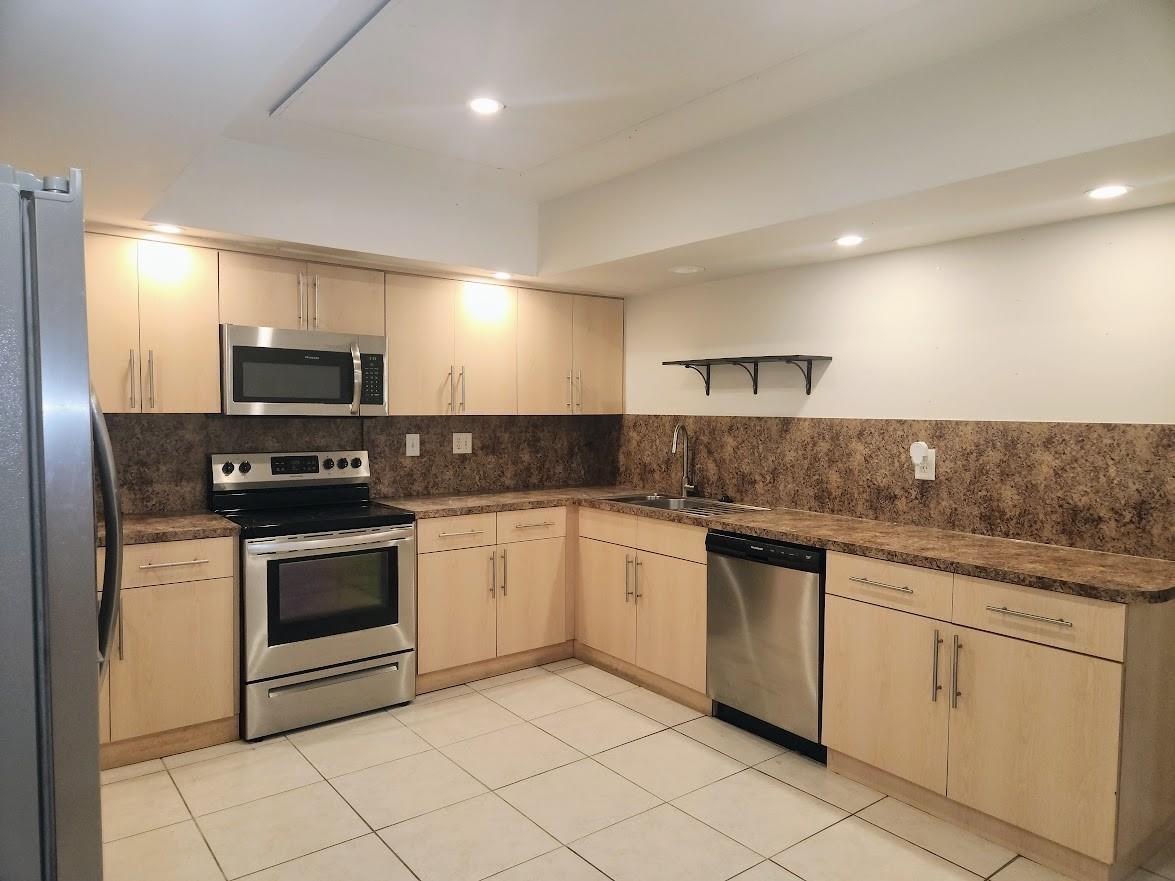 A kitchen with light wood cabinets, stainless steel appliances, and brown speckled laminate countertops — 2940 NE 19th Terrace Side, Lighthouse Point FL 33064, LIGHTHOUSE POINT, FL