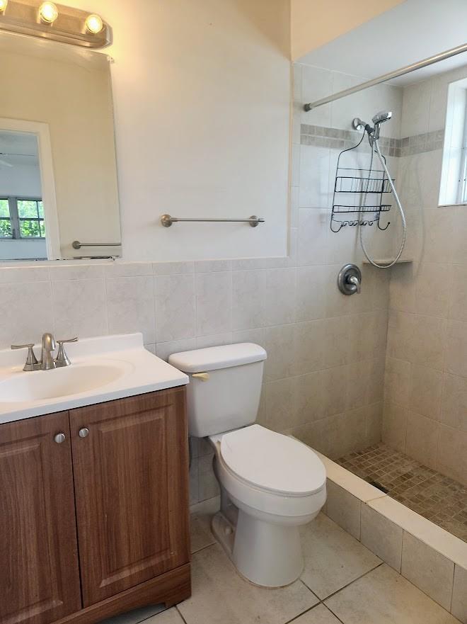 A bathroom with a wood vanity, white toilet, and a tiled walk-in shower — 2940 NE 19th Terrace Side, Lighthouse Point FL 33064, LIGHTHOUSE POINT, FL