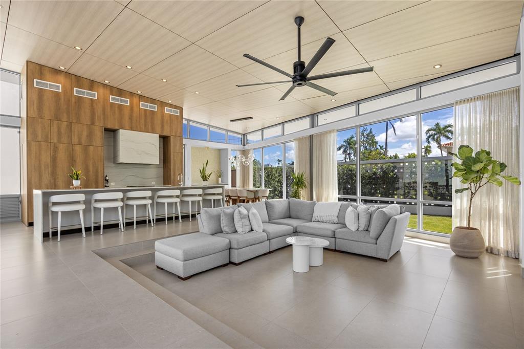 A modern open-concept living room features a sunken seating area, kitchen island, and floor-to-ceiling windows — A5 MEADOW LANE, GUAYNABO, PR