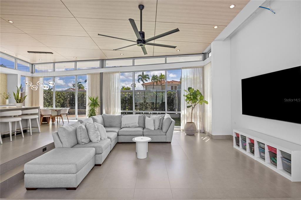 A modern living room features a large sectional sofa, a wall-mounted television, and floor-to-ceiling windows — A5 MEADOW LANE, GUAYNABO, PR