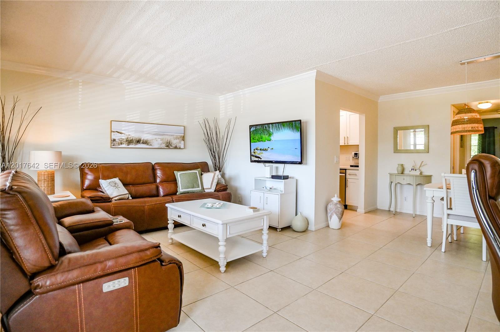 A living room features brown leather furniture, a white coffee table, and tile flooring — 62 Prescott C # 62, Deerfield Beach FL 33442, DEERFIELD BEACH, FL