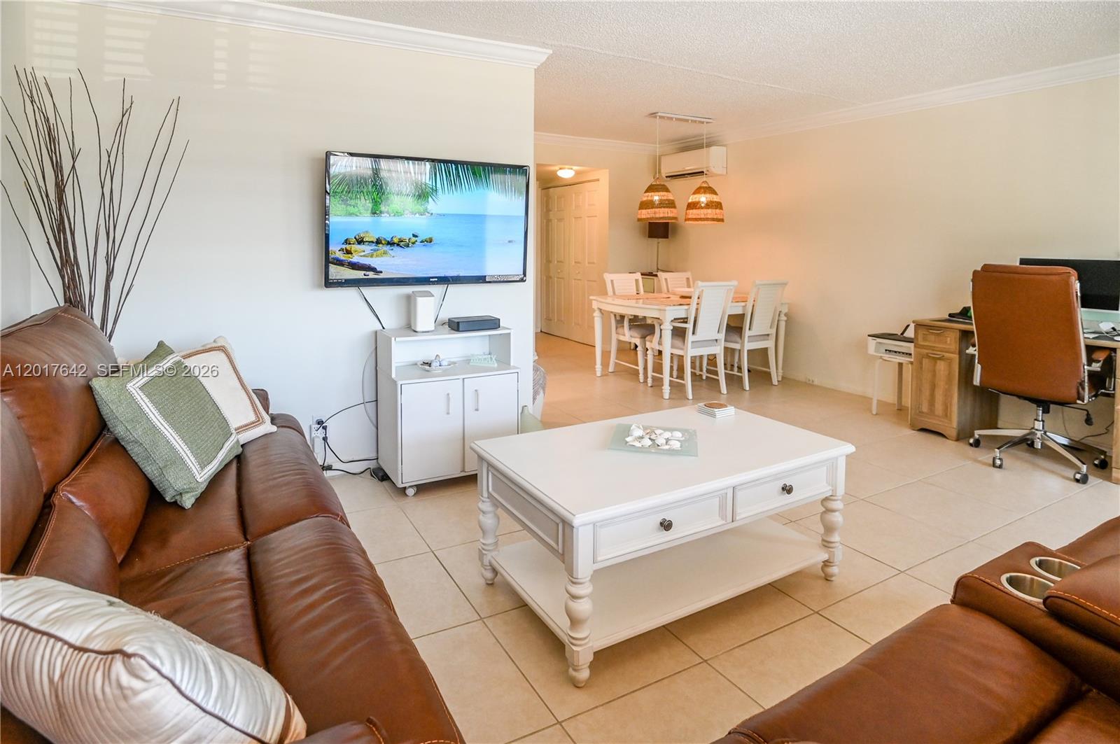 A living room features a brown leather sofa, white coffee table, and adjacent dining area — 62 Prescott C # 62, Deerfield Beach FL 33442, DEERFIELD BEACH, FL