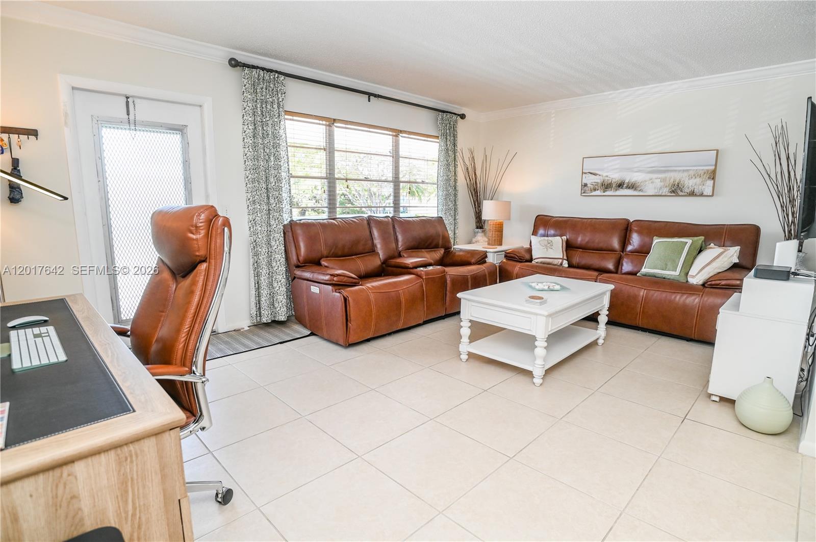 A living room features brown leather sofas, a white coffee table, and a home office area — 62 Prescott C # 62, Deerfield Beach FL 33442, DEERFIELD BEACH, FL