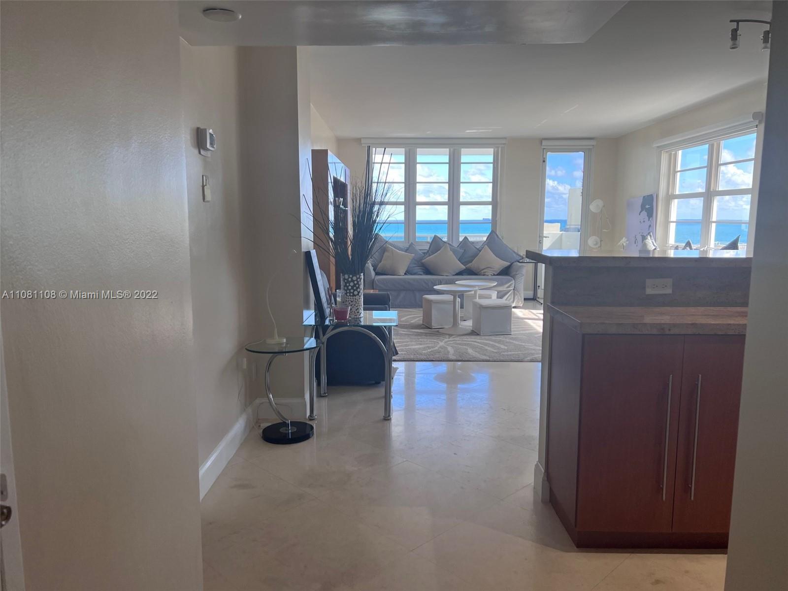 An open-concept living room features light tile floors, a kitchen island, and ocean views — 100 Lincoln Rd # 1121, Miami Beach FL 33139, MIAMI BEACH, FL