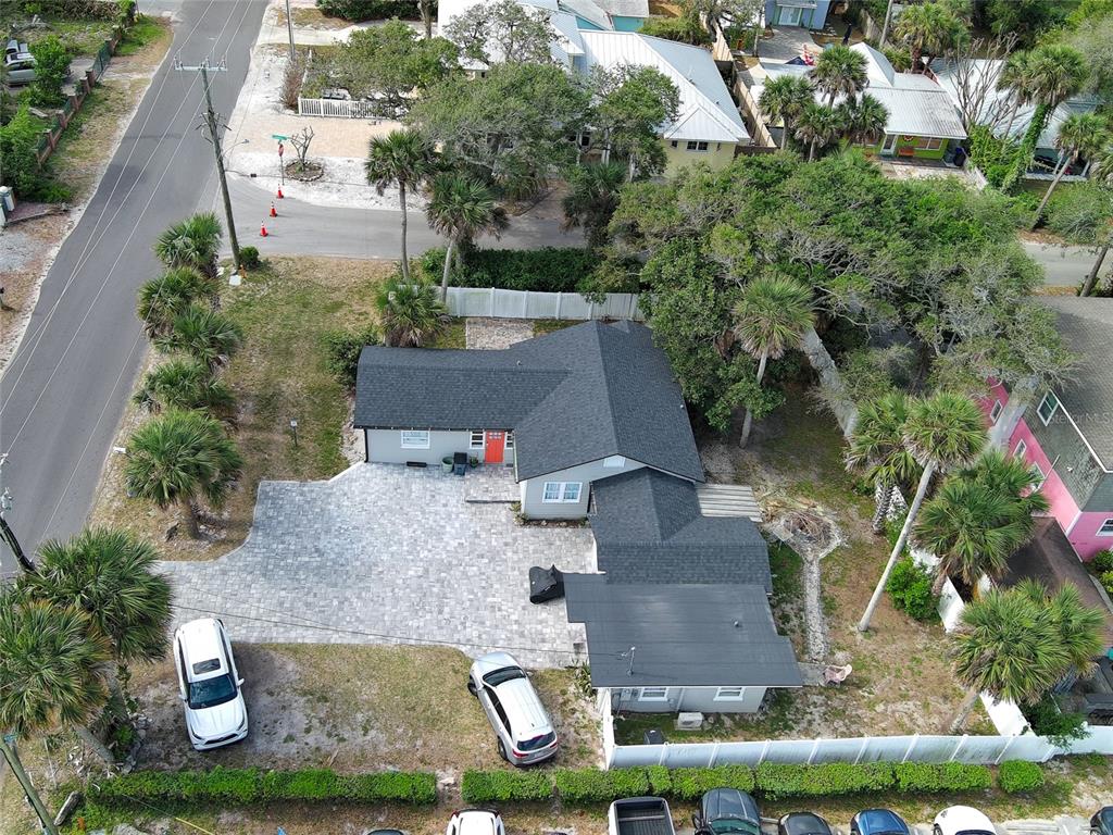 An aerial view shows a single-story house with a gray roof and paved driveway — 200 S PINE STREET, NEW SMYRNA BEACH, FL