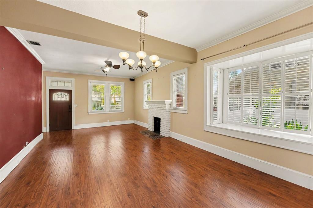 A living room features hardwood floors, a white brick fireplace, and a large bay window — 450 13TH AVENUE N, ST PETERSBURG, FL