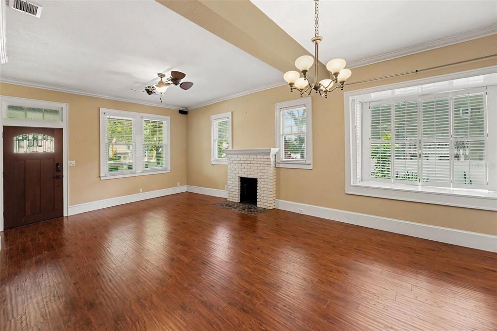 A living room with hardwood floors, a brick fireplace, and a large bay window — 450 13TH AVENUE N, ST PETERSBURG, FL