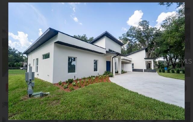 A modern white house with a flat roof, blue front door, and a concrete driveway — 2902 ROBINSON ROAD, PLANT CITY, FL