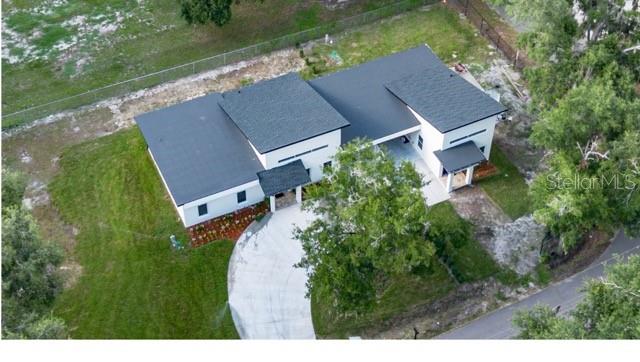 An aerial view shows a modern white house with a dark roof and a concrete driveway — 2902 ROBINSON ROAD, PLANT CITY, FL