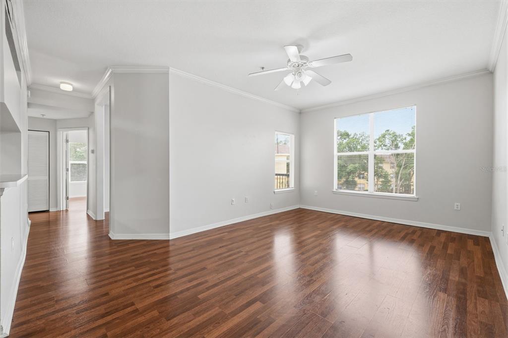 An empty living room features light gray walls, dark wood flooring, and a ceiling fan — 5612 PINNACLE HEIGHTS CIRCLE UNIT 312, TAMPA, FL