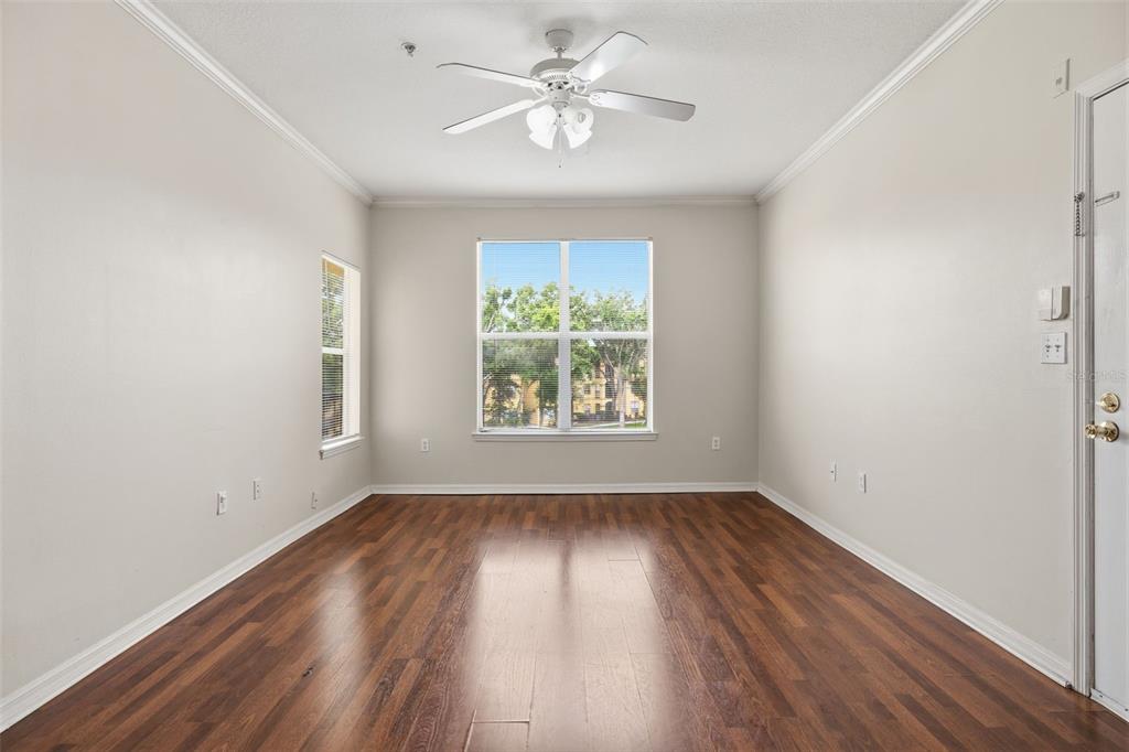 An empty room with wood-look flooring, a ceiling fan, and a large window — 5612 PINNACLE HEIGHTS CIRCLE UNIT 312, TAMPA, FL