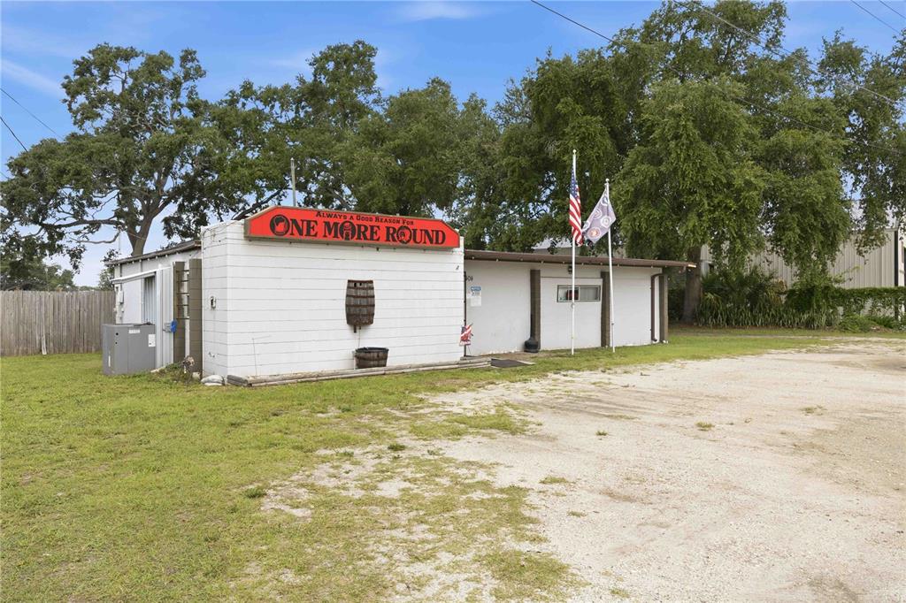 A white cinder block building with a red sign reading One More Round sits outdoors — 404 EAKER STREET, AUBURNDALE, FL