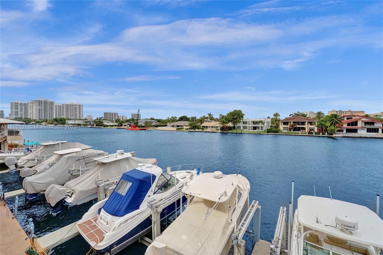 Several boats are docked at a waterfront property with residential buildings in the background — 1965 S Ocean Dr # 7K, Hallandale Beach FL 33009, HALLANDALE BEACH, FL