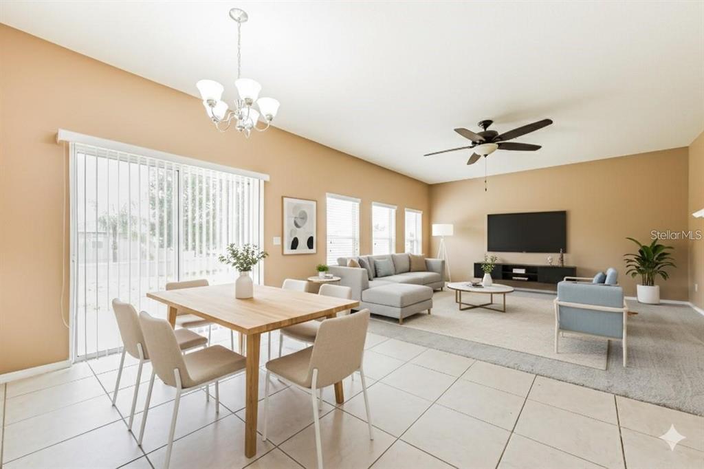 An open-concept living and dining area with tile floors, a sectional sofa, and a chandelier — 30207 CHEVAL STREET, MOUNT DORA, FL
