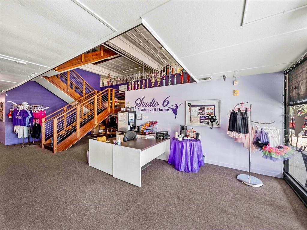 A dance studio reception area features a wooden staircase, a desk, and purple wall accents — 247 E STUART AVENUE, LAKE WALES, FL